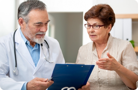 Stock photo of female patient discussing health complaints with doctor in a medical exam. 
